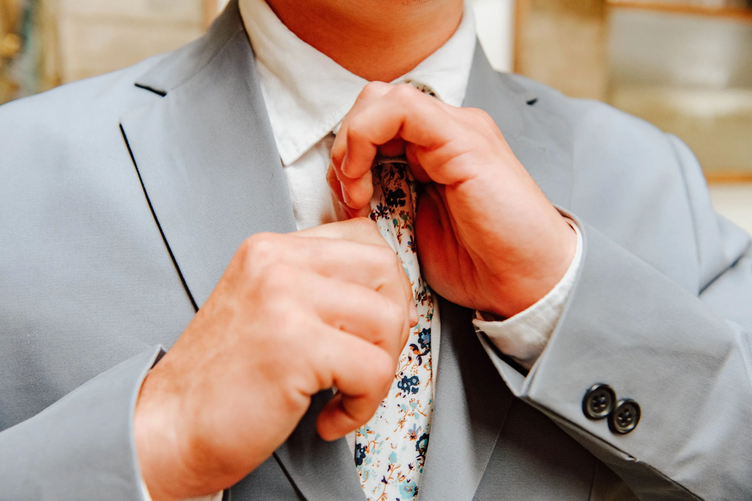 Groom adjusting his tie before the wedding ceremony