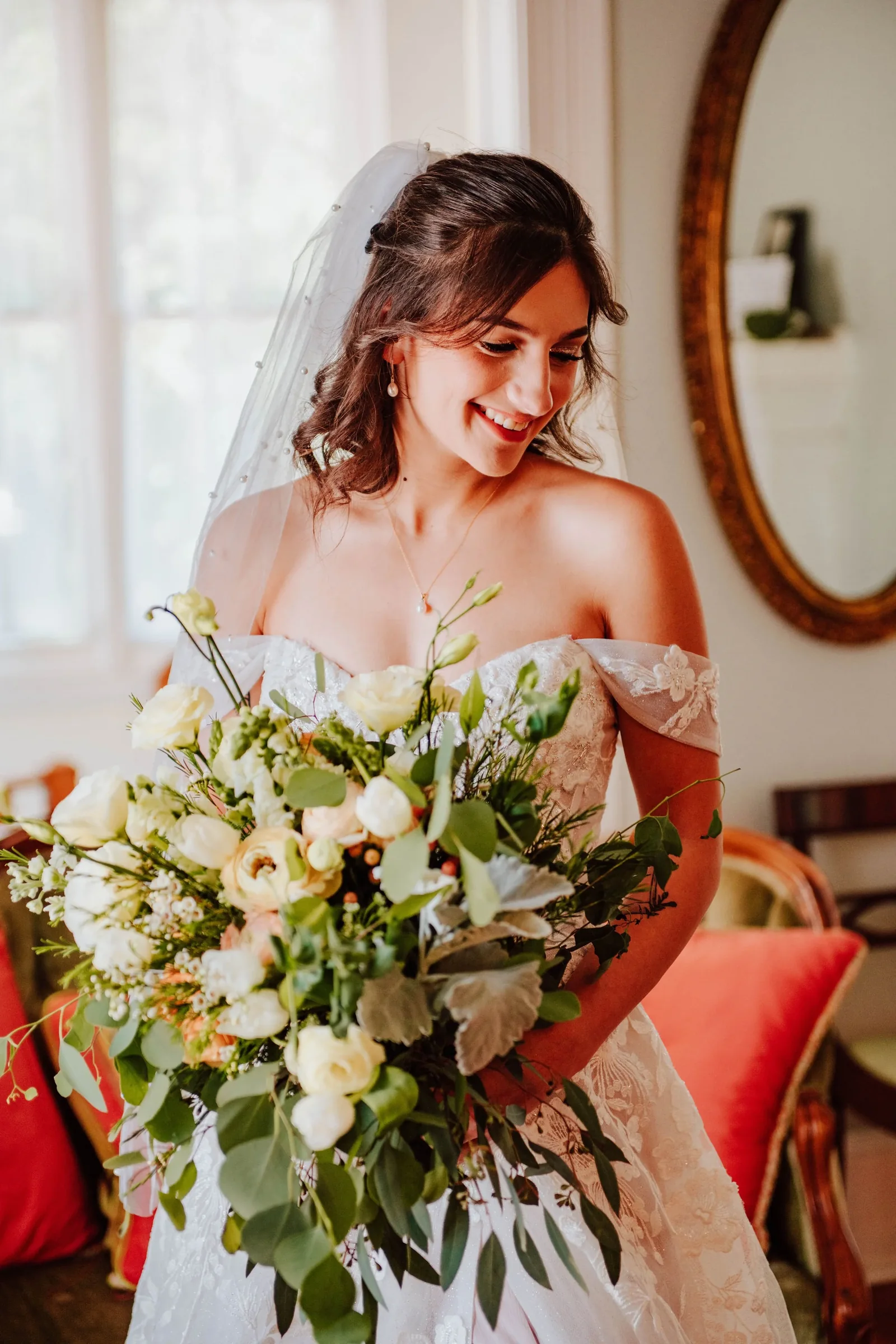 Bride holding her bouquet in soft window light